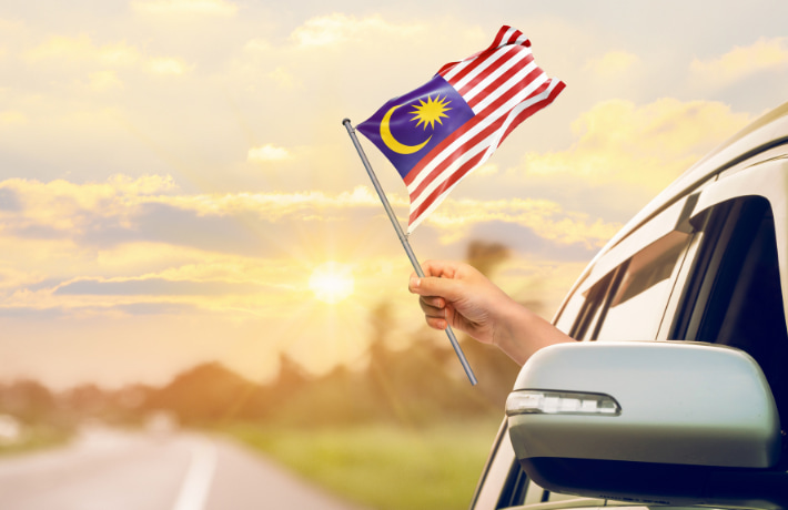 車からマレーシアの国旗を振る人